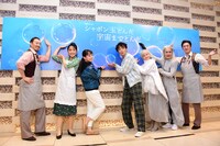 カメラマンのリクエストに応じ、看板に描かれたシャボン玉に触れるようにポーズをとる出演者たち。