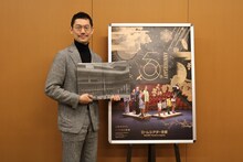 ロームシアター京都 開館5周年記念事業 取材会より。ロームシアター京都 開館5周年記念誌を手にした橋本裕介。