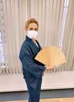 青色の着物をまとい、扇を広げてしゃんと立つ桐生。