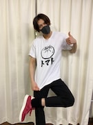 モノトーンに筆文字が潔い、トマトのTシャツでポーズ。トマトのイラストは白黒だが、シューズはレッドで元気よく。