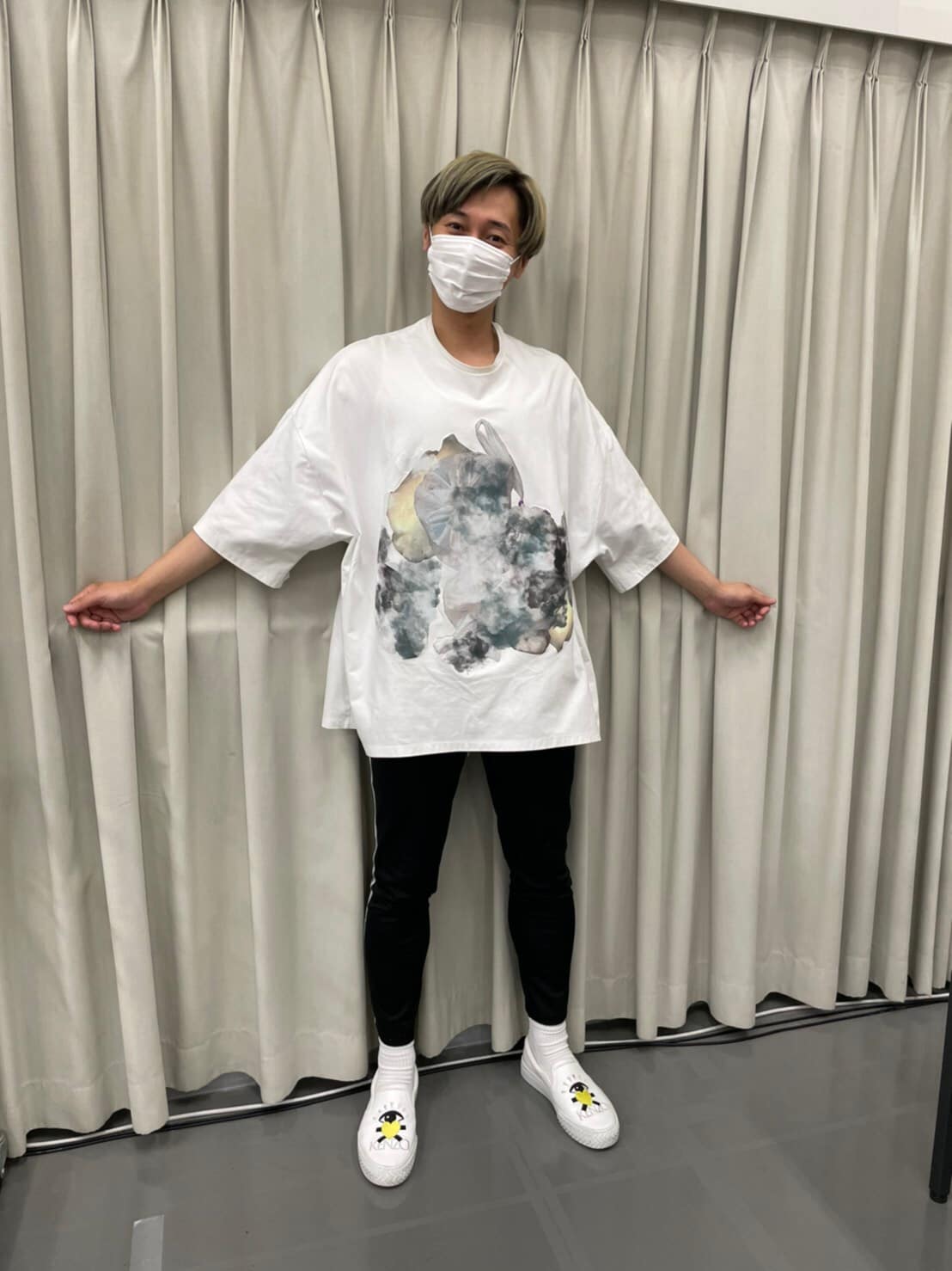 大きめサイズのプリントTシャツと、キュートなKENZOのシューズを身に着けた後上。