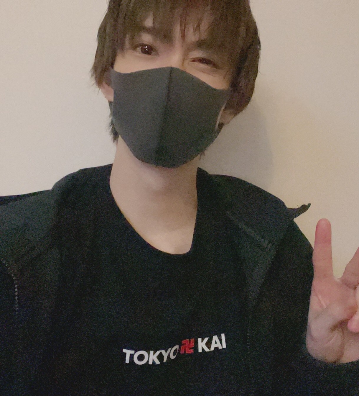 東京卍會のロゴ入りTシャツでピース。黒っぽいマスクを合わせてクールに。