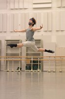 グレーのタンクトップにオフホワイトカラーのタイツを合わせ、上下を淡いトーンで統一したコーディネート。