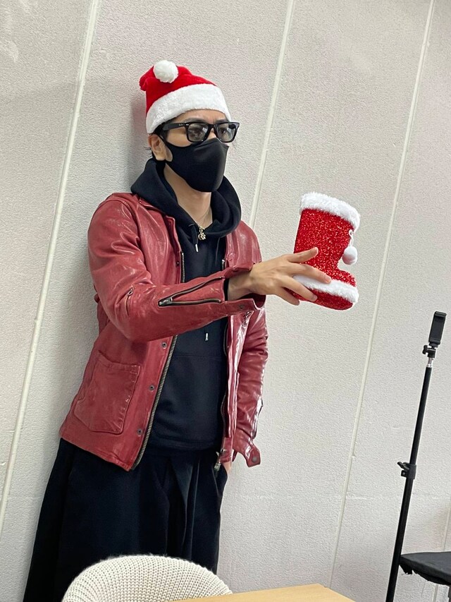 靴下ははかずに手に持つのが久保田スタイル。赤い革ジャンがサンタ気分を盛り上げる。
