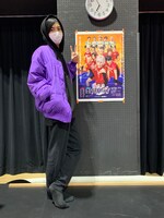 パープルのダウンで温かさをプラス。舞台「灼熱カバディ」ポスターの横でピース！