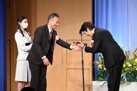 高橋一生（右）にブロンズ像を渡す、プレゼンターの山崎一（左）。