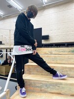 黒パーカーからチラリとのぞく、Tシャツのピンク文字がアクセント。