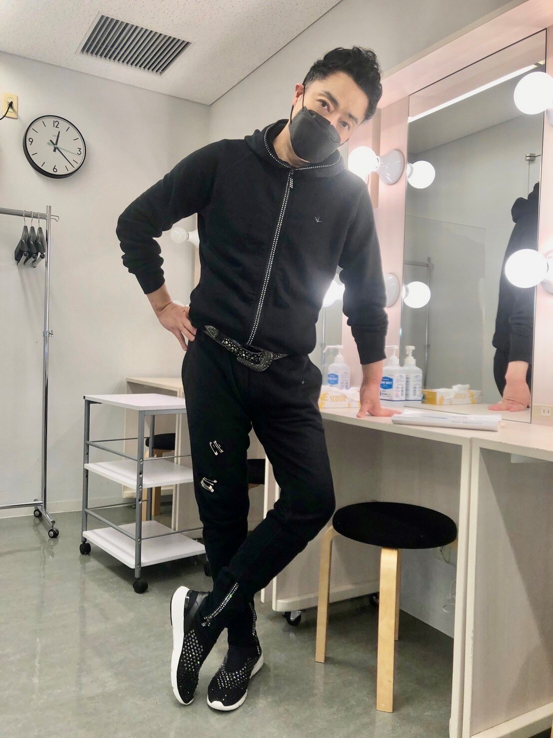 マスクまで黒でそろえたシックなコーデだが、ファスナーやベルト、足元でさりげなくラインストーンが輝いている。