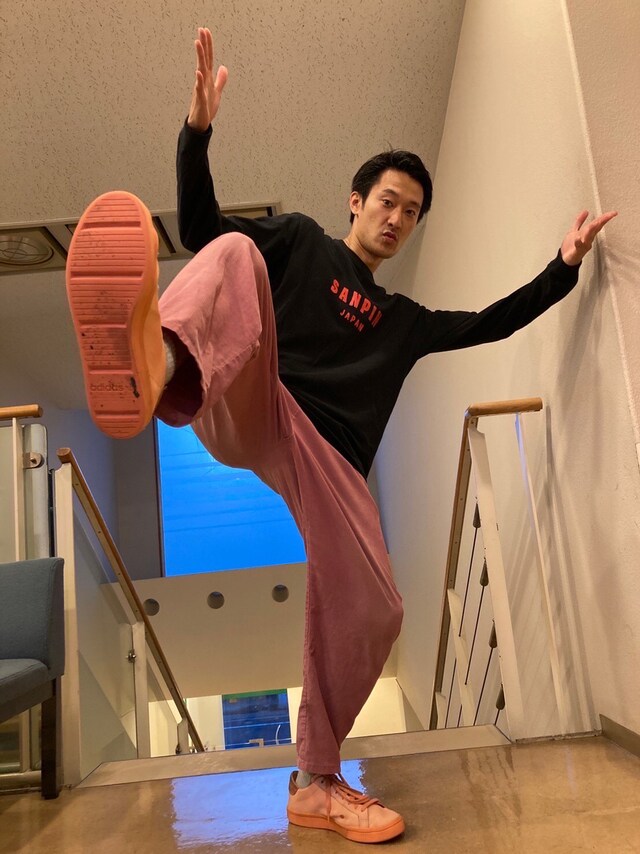 自身が所属する演劇ユニット・さんぴんのロンTを着用。