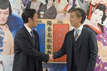 カメラマンから握手のポージングを求められ、おずおずと握手する中村勘九郎（左）と中村七之助（右）。