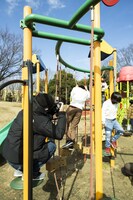 自ら遊具に入り込みつつ、夢中で佐野家3兄弟を追いかけ撮影する竪山隼太。（撮影：平岩享）