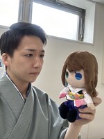 ユウナ人形をなんともいえない表情で見つめる米吉。