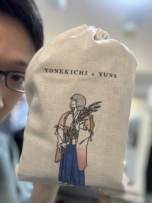 ファンお手製のグッズ！ 米吉の名前にちなみ、稲穂を手にしているユウナがキュート。見切れているメガネ姿の米吉にも注目。