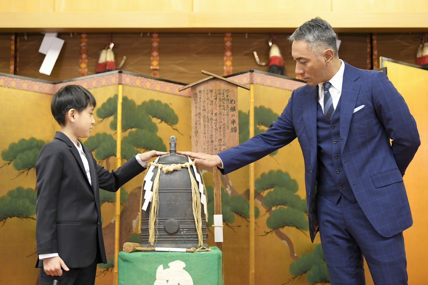 “め組の半鐘”に触れる市川團十郎（右）と市川新之助（左）。