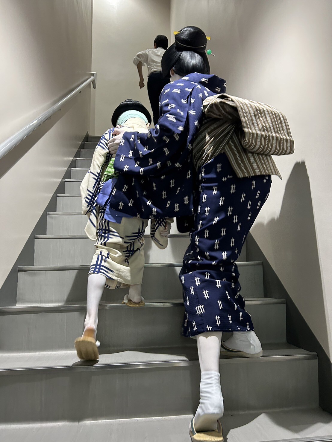 うんしょ、うんしょ…と階段を上がっていくヒトくんと、サポートするママ・米吉。そんな2人を先導する白シャツ姿の男性は、ヒトくんのリアルパパ・尾上菊之丞！