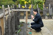 杉野十平次の墓に手を合わせる坂東亀蔵。