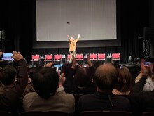 「劇団つかこうへい事務所 一夜限りの大同窓会」より、客席にバラの花を投げる石丸謙二郎。