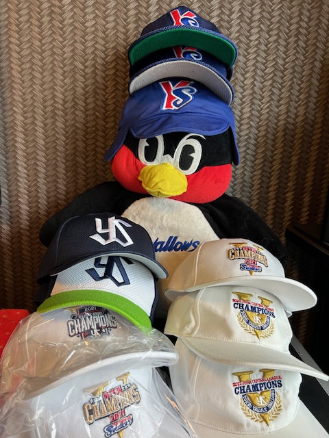 金山が所持している東京ヤクルトスワローズのキャップコレクション。同チームのマスコット・つば九郎のパペットも。