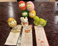 今回出たおみくじたち。背後のダルマさんたちも内容が気になる様子。