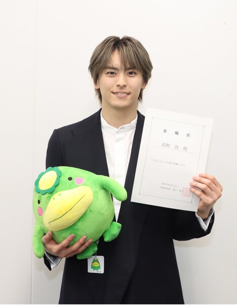 くるめふるさと大使委嘱状と、くるっぱのぬいぐるみを持つ高野洸。