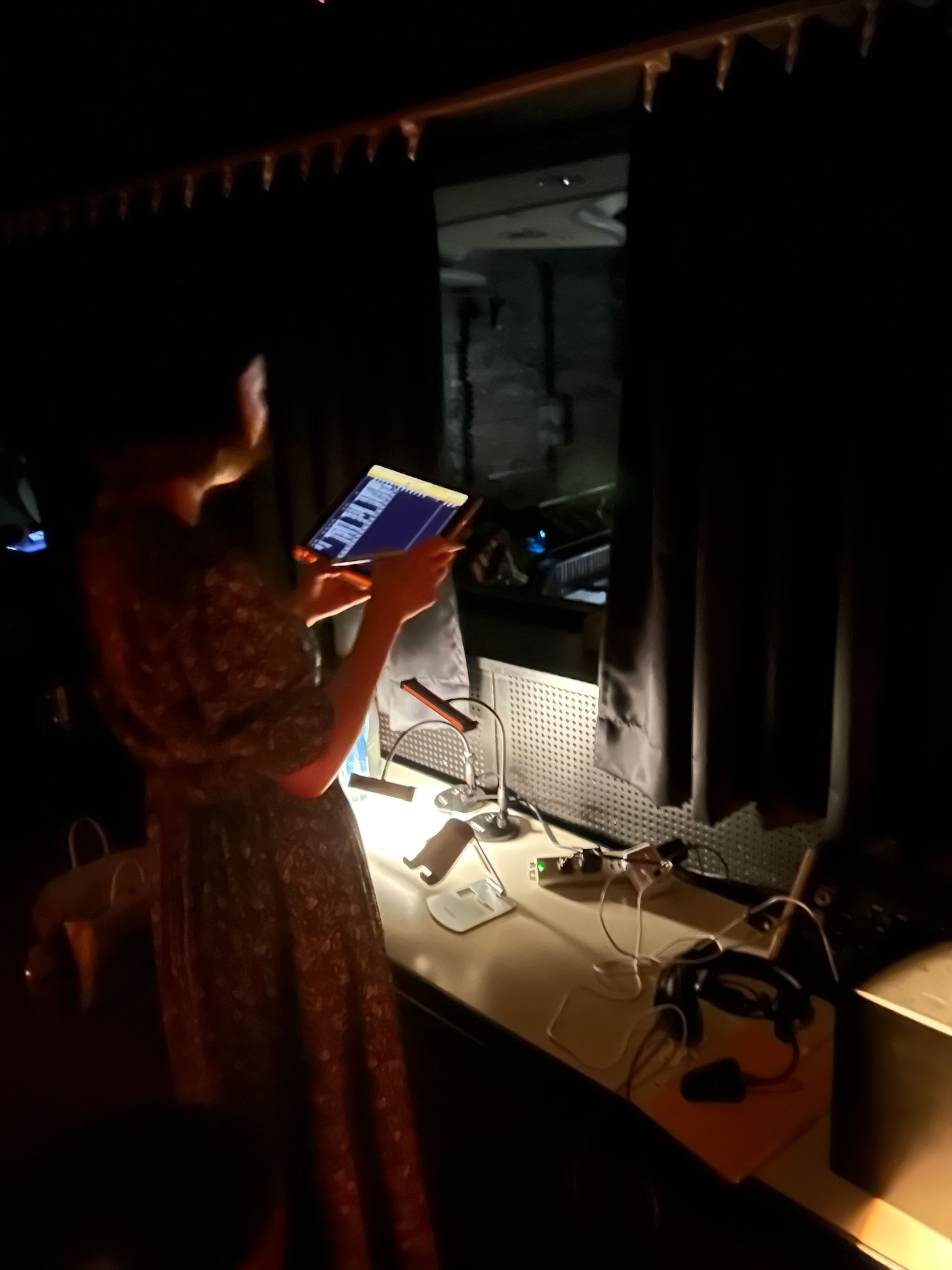 「三人吉三廓初買」での持丸さんの音声描写風景。本番の舞台をブースから見ながら、絶妙のタイミングでナレーションを入れていく。基本的には練りに練られたナレーション台本をもとに行われるが、時に俳優のアドリブに合わせて、臨機応変にガイドすることも。