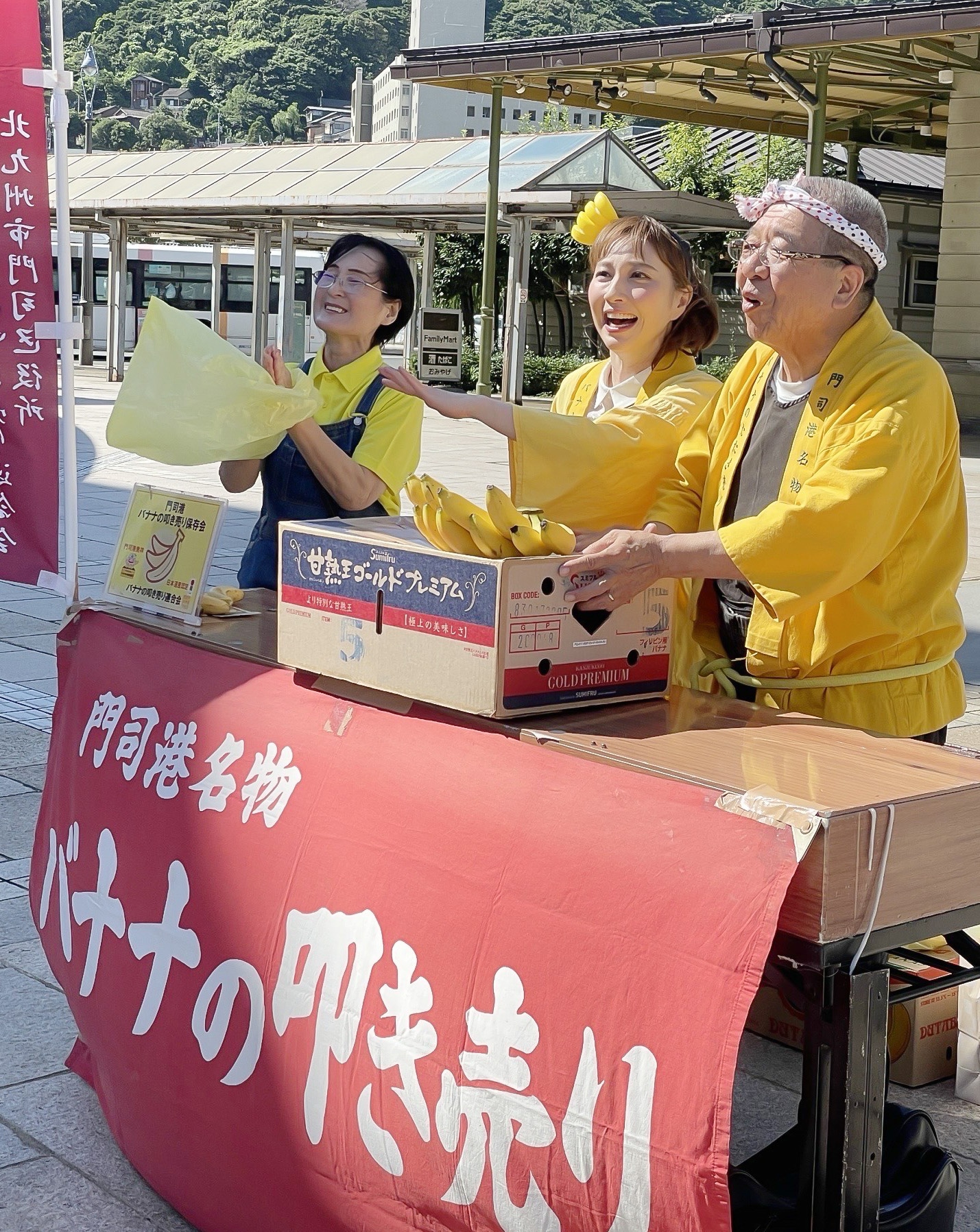 8月20日にBS-TBSで放送される「美しい日本に出会う旅」より、バナナを叩き売りをするはいだしょうこ（写真中央）。