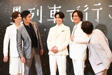 カメラマンの「石井さんの笑顔が素晴らしい」というコメントを聞き、石井一孝（右から2番目）の顔をのぞき込む共演者たち。