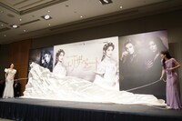 望海風斗（左）と明日海りお（右）が、息を合わせてパネルからベールを落とす様子。