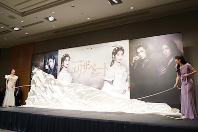 望海風斗（左）と明日海りお（右）が、息を合わせてパネルからベールを落とす様子。