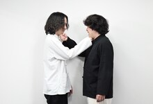 互いの手にあごを乗せる中村亮太（左）、平山犬（右）。