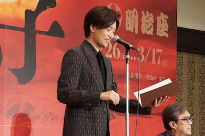 舞台「大地の子」製作発表会見より。栗山民也のコメントを代読するためにマイクの前に立ち、「緊張する」と照れ笑いする井上芳雄。