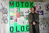 MOTOKOLOGYの看板の前で、森山未來。