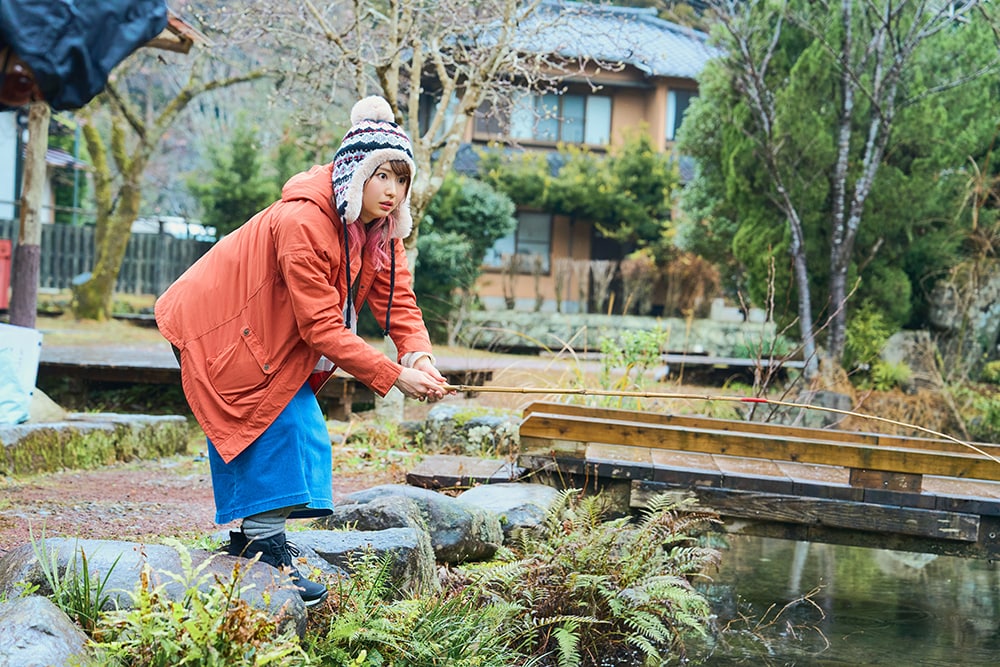 ニジマス釣りのパートより、真剣な面持ちで釣りに挑む戸松遥。