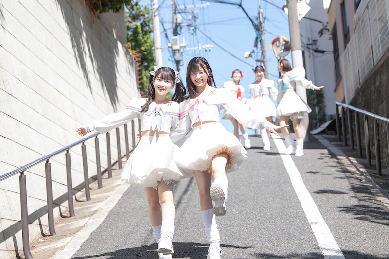 肩を組んで坂を下る小鳥遊るい（左）と宇咲（右）。