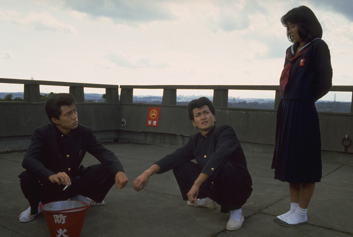 映画「ビー・バップ・ハイスクール」より。左から仲村トオル扮するトオル、清水宏次朗扮するヒロシ、中山美穂扮する今日子 ©︎1985 東映 セントラル・アーツ