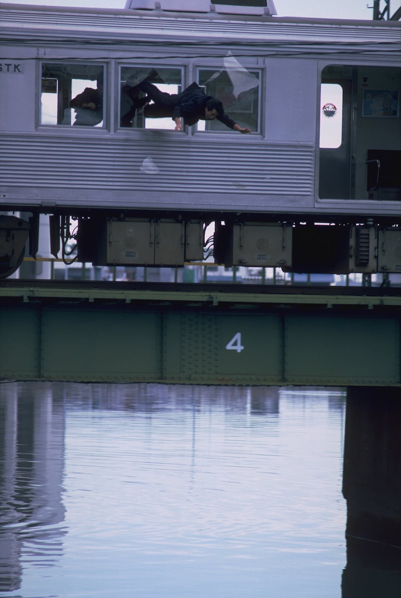 1作目「ビー・バップ・ハイスクール」より。電車内で乱闘が行われるシーンでは、電車が川の上の鉄橋に差し掛かったところで、割れた窓から人間が川に落とされる ©︎1985 東映 セントラル・アーツ