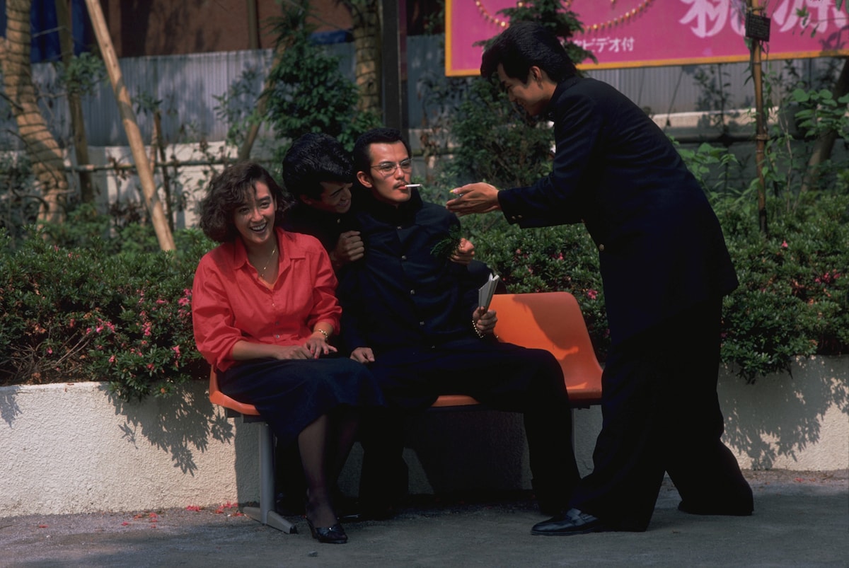 映画2作目「ビー・バップ・ハイスクール 高校与太郎哀歌」より、石井博泰扮する菊永淳一（中央）。立花商業の大将で、トレードマークの口ひげと老け顔のせいで本職のヤクザに間違えられやすい ©︎東映