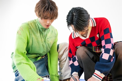 ハート型ボードにメッセージを書き入れるTAKUYAとYUMA。