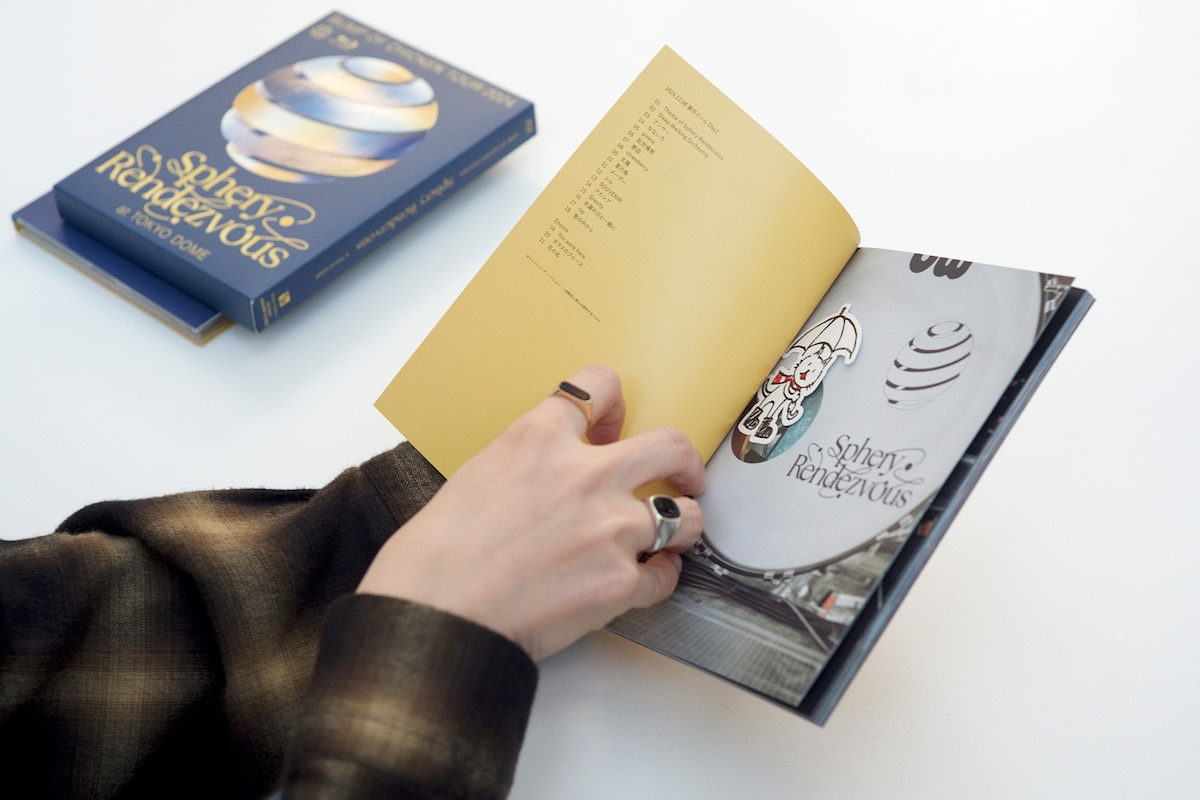 「BUMP OF CHICKEN TOUR 2024 Sphery Rendezvous at TOKYO DOME」に封入されるフォトブックとニコルステッカー。（撮影：太田好治）