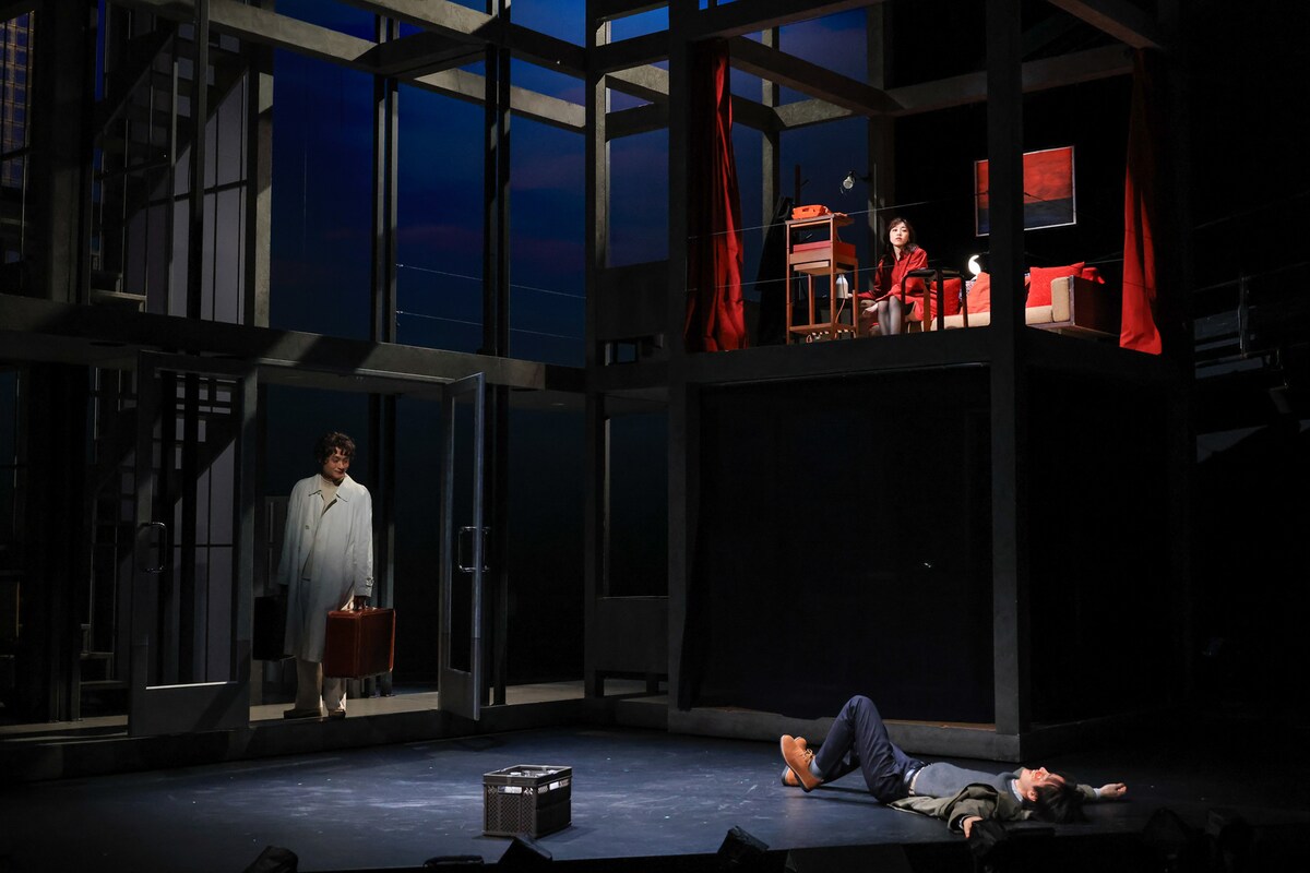 舞台「デカローグ6 ある愛に関する物語」より、荷物を持ち、旅人に扮して登場した亀田佳明（左奥）。（撮影：宮川舞子）