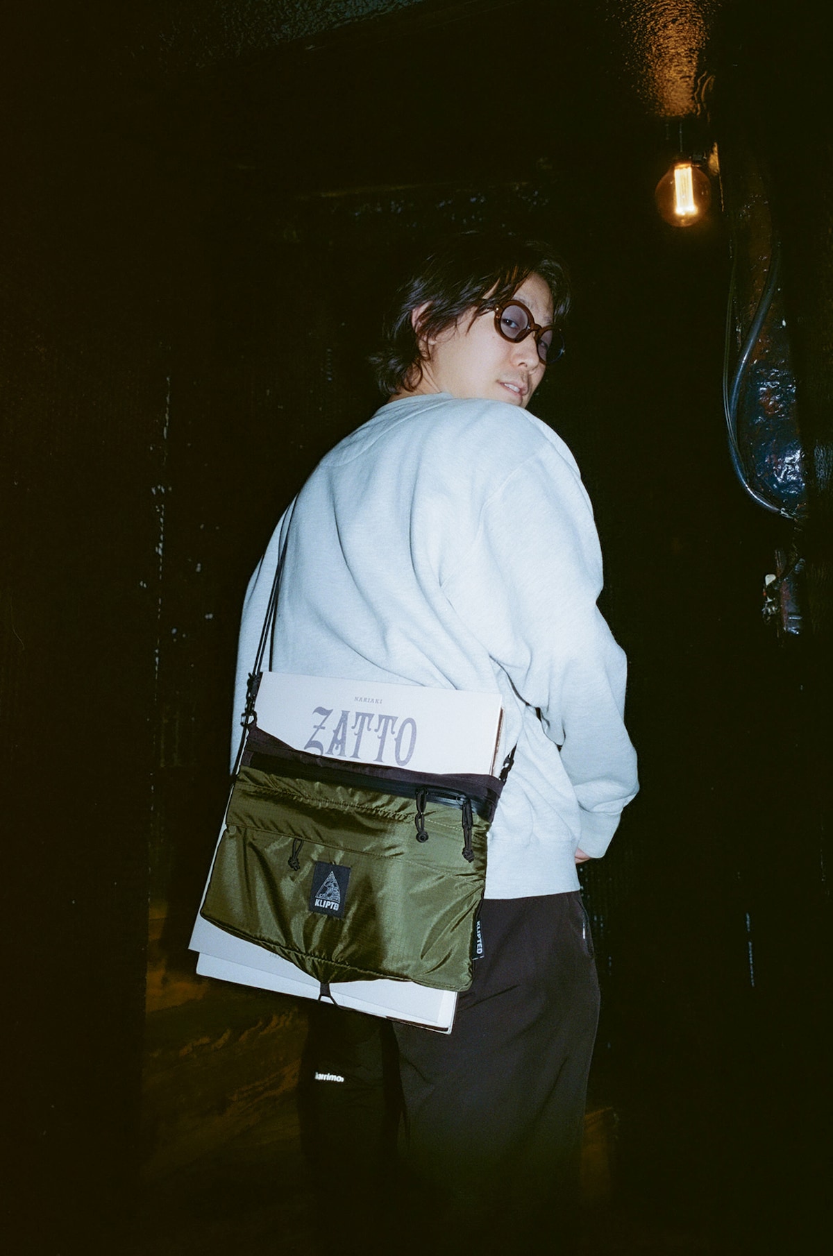 小袋が背負っているショルダーバッグは、彼の地元であるさいたま市・浦和発のブランド・KLIPTEDのもの。背面にレコードを固定するためのドローコードが付いており、小袋は「Zatto」を含むレコード4枚を入れて取材現場に現れた。