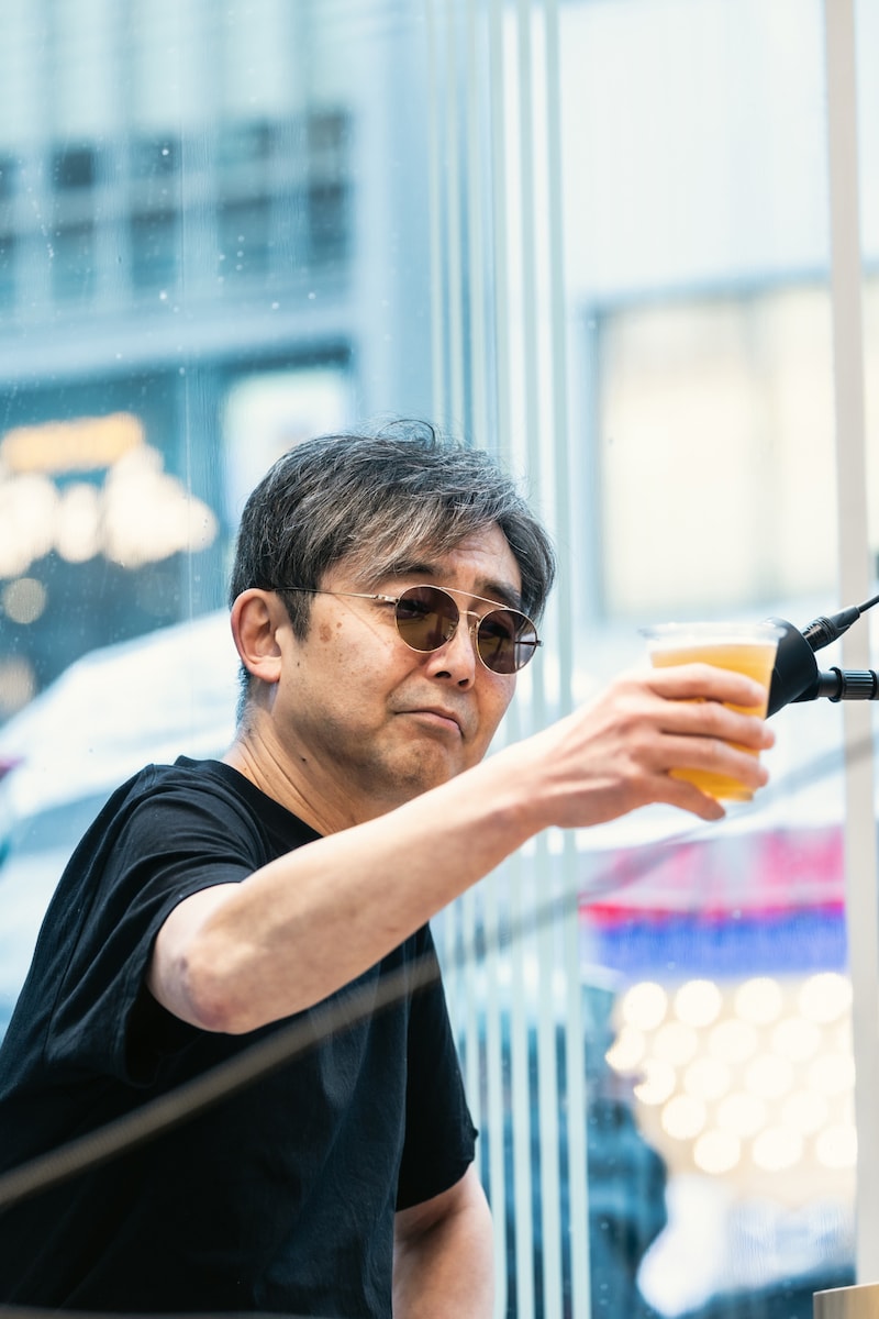 「FENDER CAFE」のクラフトビールで乾杯する向井秀徳。