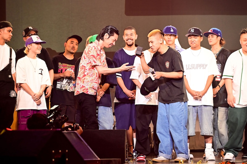 呂布カルマから賞品を受け取るビシキマ。