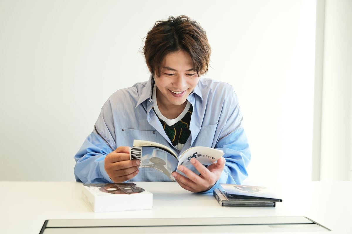 特典の描き下ろしコミックを読む青柳尊哉。