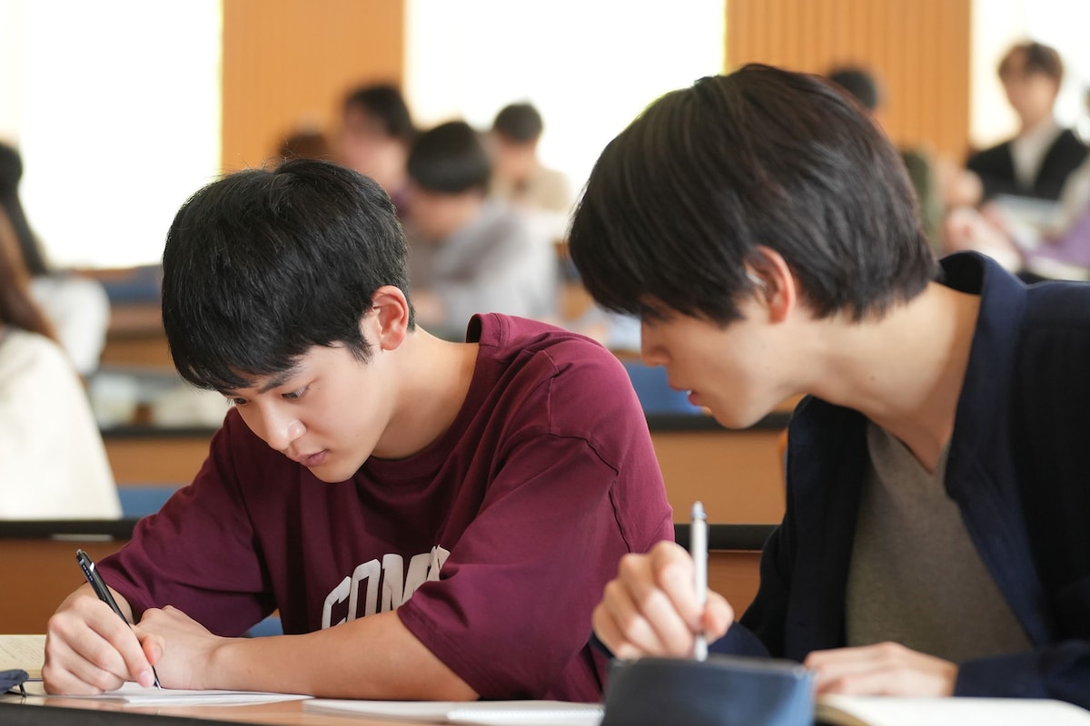 お弁当と引き換えに、太一にノートテイクをしてもらうことになった航平。講義中、太一は教授が話している内容をノートに書いていき、航平はその内容を確認する。©「ひだまりが聴こえる」製作委員会
