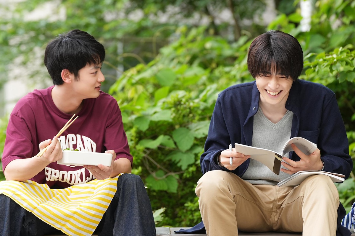 弁当を頬張りながら「こんなに美味しいものばかり食べてバチが当たらないかな」と心配する太一。そんな太一の発言を受け、航平は初めて彼の前で笑顔を見せる。©「ひだまりが聴こえる」製作委員会