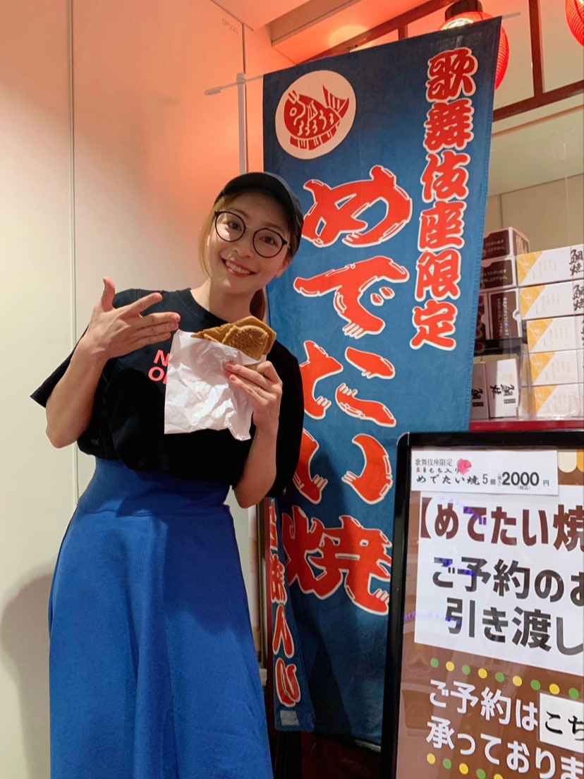 内田慈と、アツアツできたてのめでたい焼き。紙からたい焼きの顔がひょっこり！