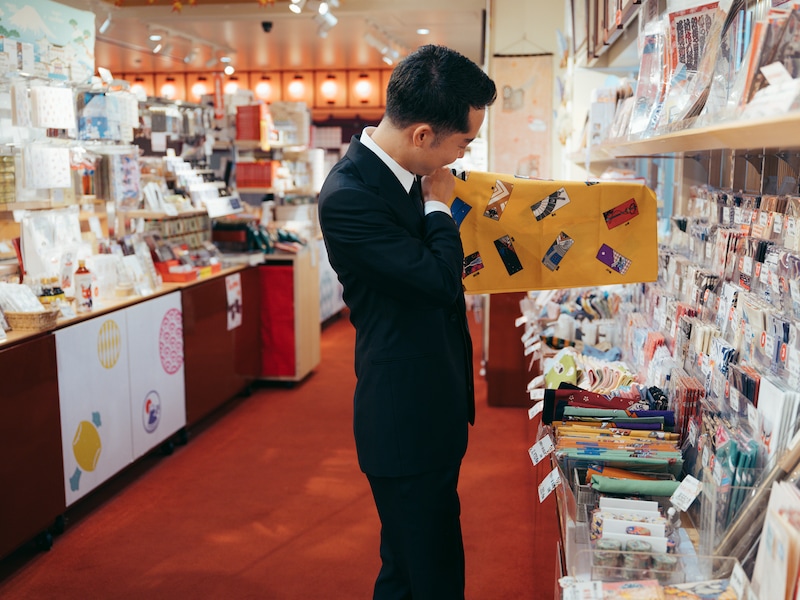 1階お土産処「木挽町」で、手ぬぐいを見る虎之介。