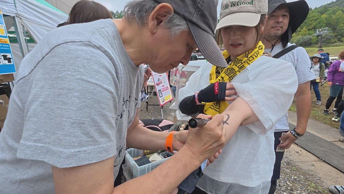 来場者の腕にイラストを描く奈良美智（「風とロック芋煮会2025」本編映像より）