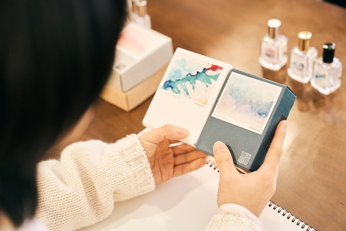 箱を見比べる小林千晃の手元。